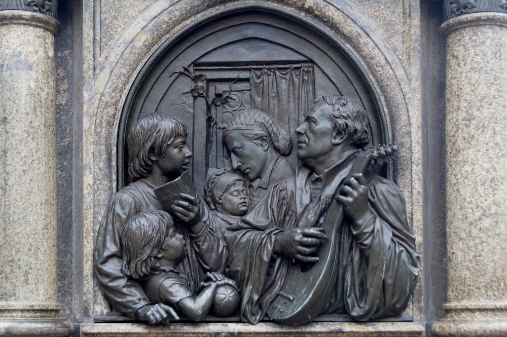Sculptural relief of Martin Luther playing music with his family.