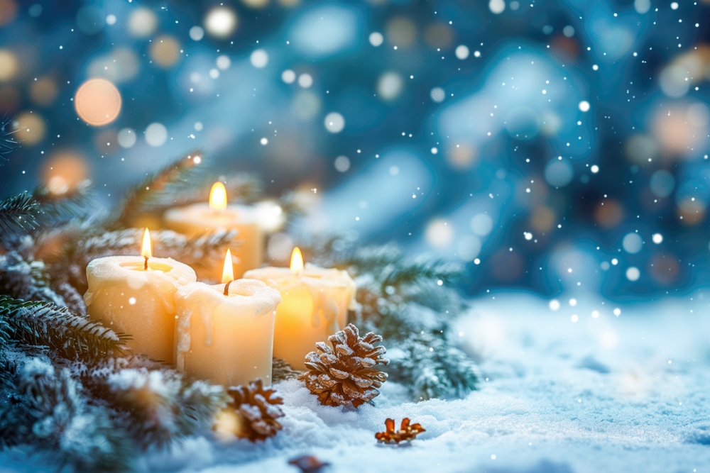 Candles glow, surrounded by pine boughs on a snowy night.